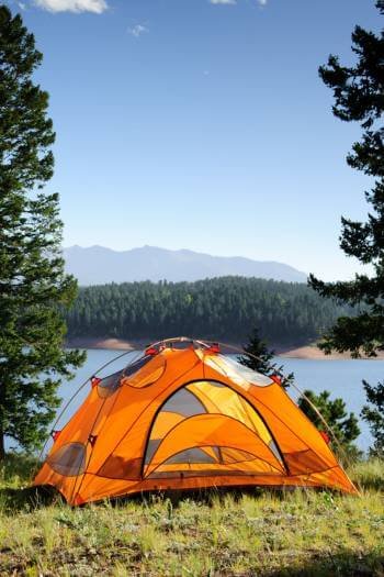 a camping tent infront of a river