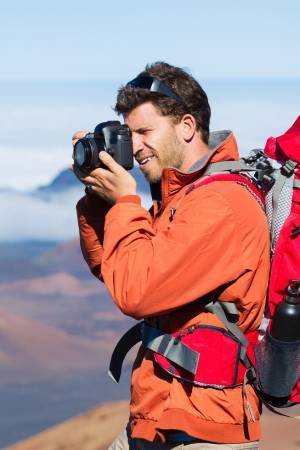 man capturing picture with camera during hike